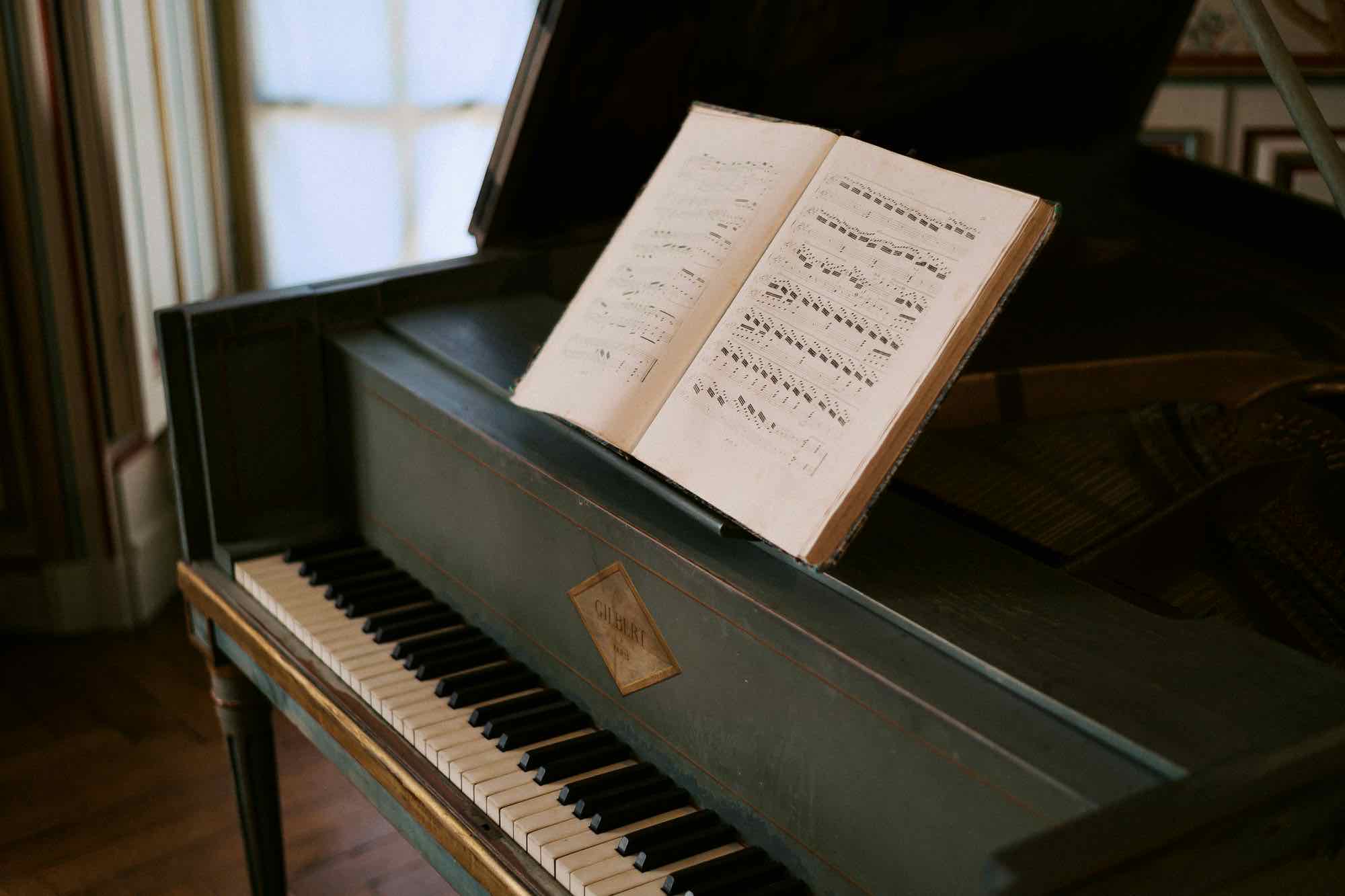 A bound score open on an antique piano in a Paris salon